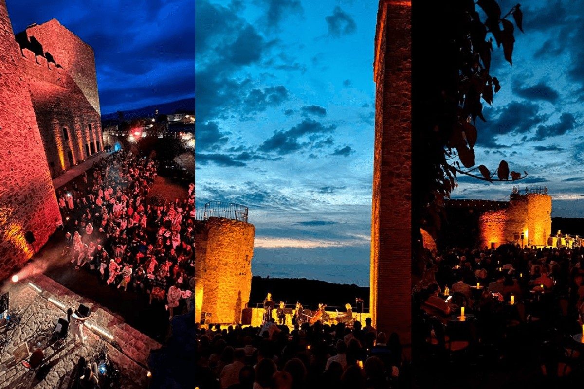 Concierto nocturno en el castillo, con público y escenario iluminado