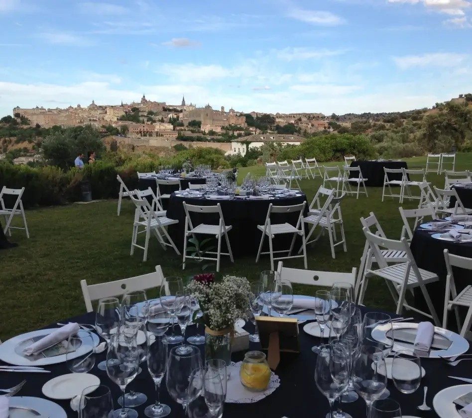 Mesas y sillas blancas preparadas para un evento al aire libre en el campo