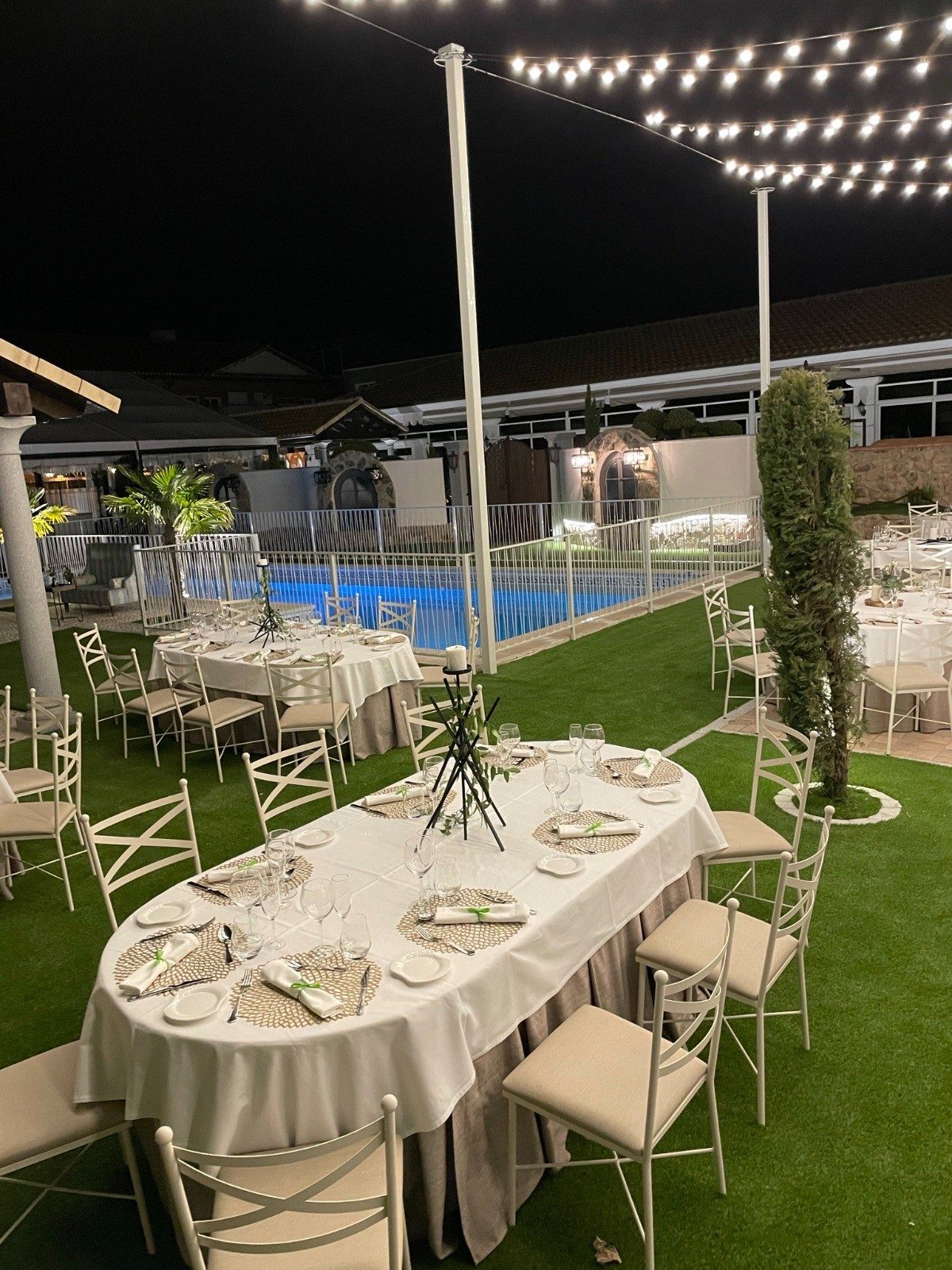 Cena al aire libre junto a la piscina, de noche