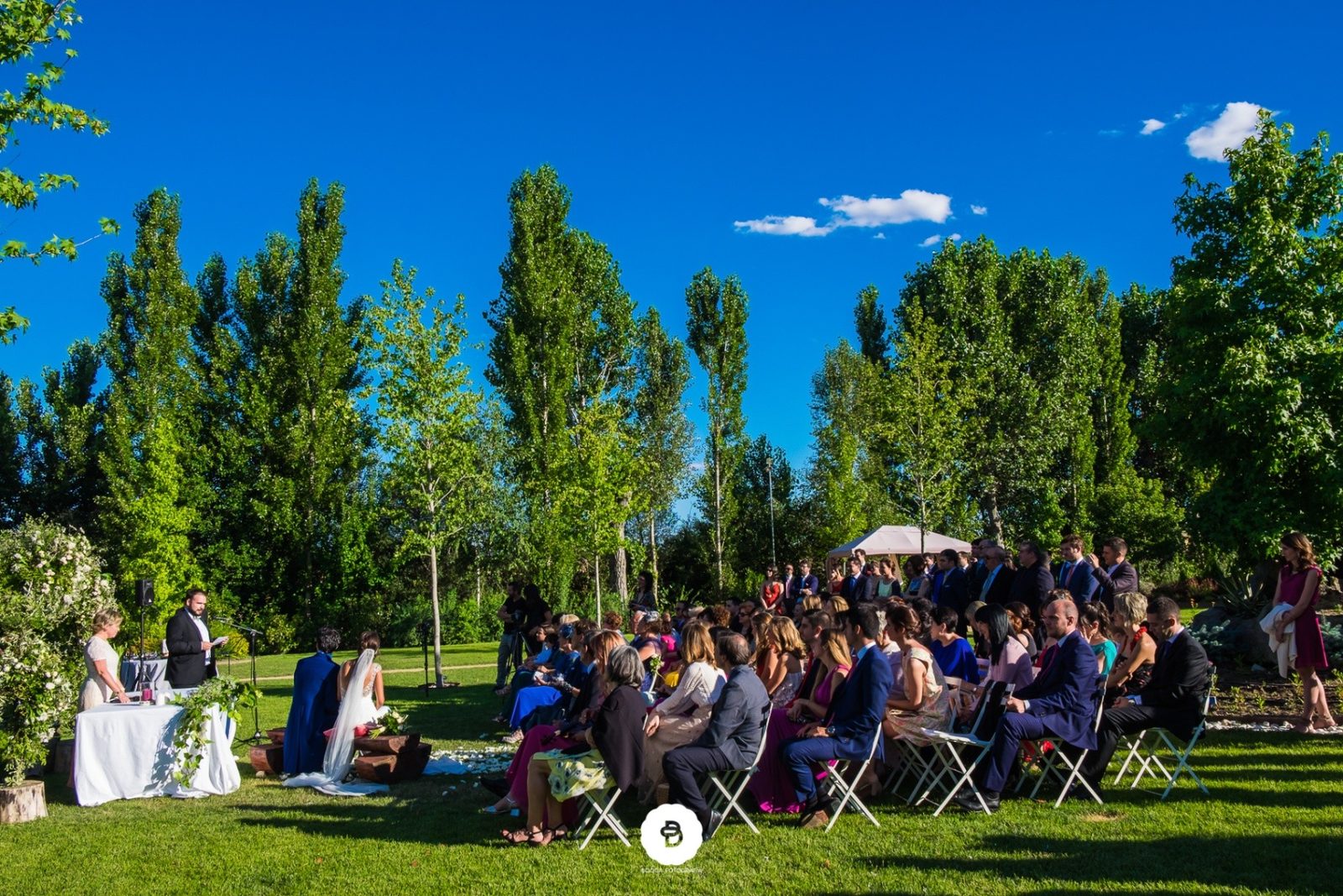 Plano general de una ceremonia exterior con invitados en el entorno natural