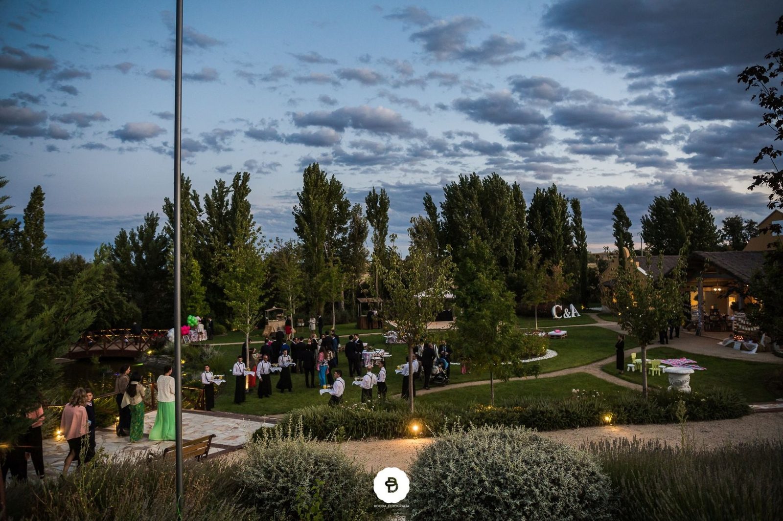 Recepción al anochecer con invitados en los jardines