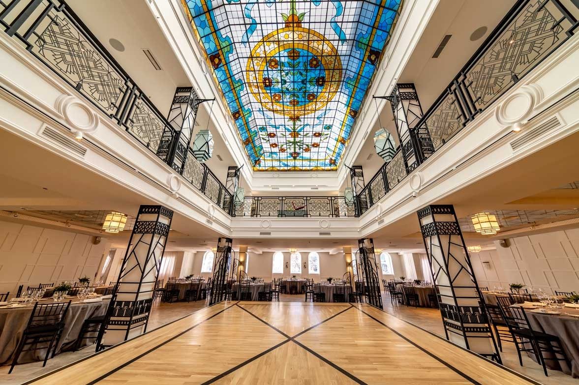 Salón con techo de vidriera y mesas montadas para un evento