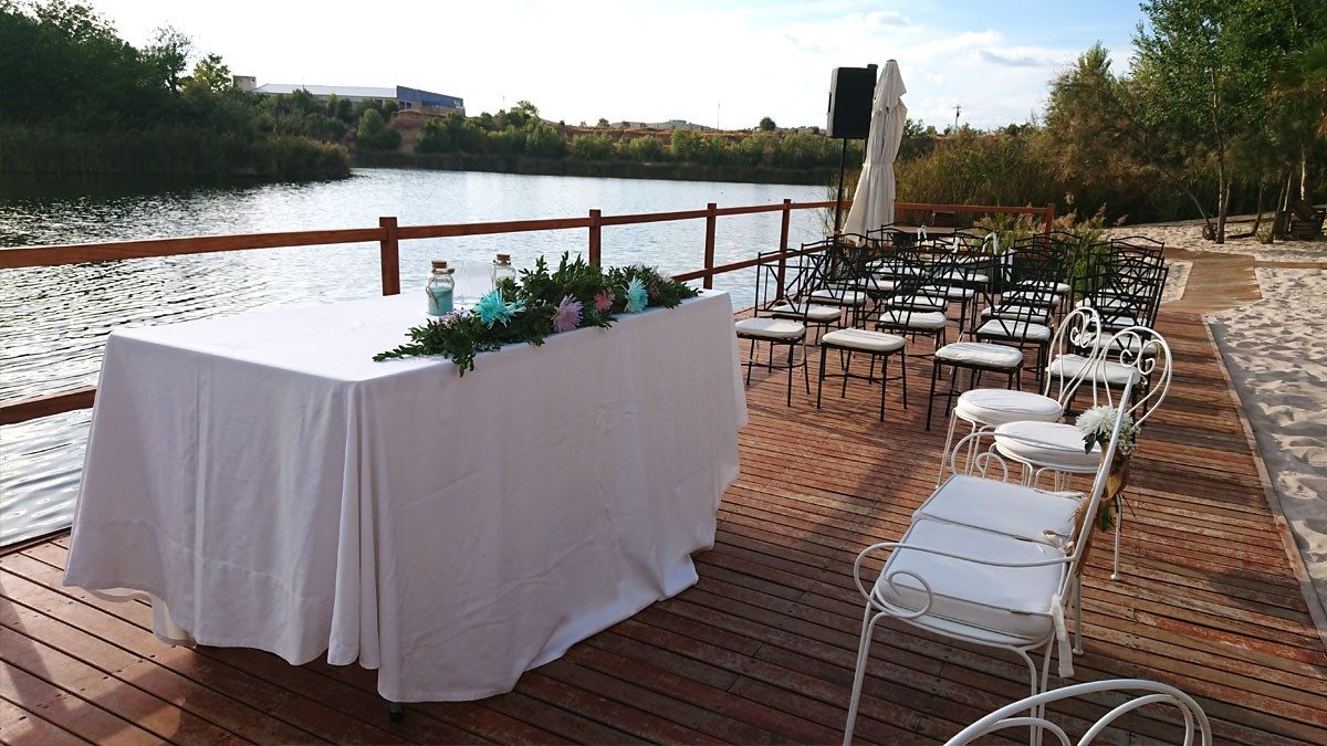Ceremonia en la playa con embarcadero de la laguna