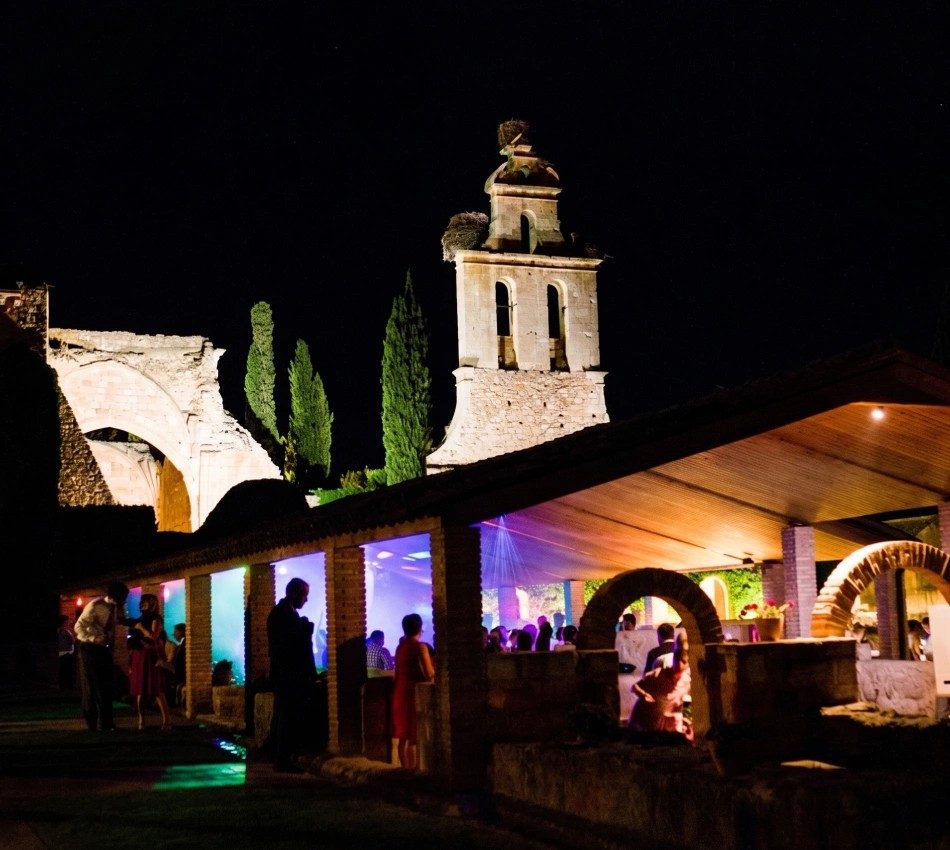 Fiesta nocturna con invitados bajo una estructura iluminada