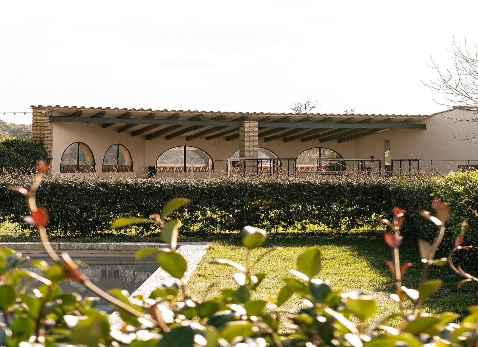 La piscina y el porche, en el jardín central de la finca