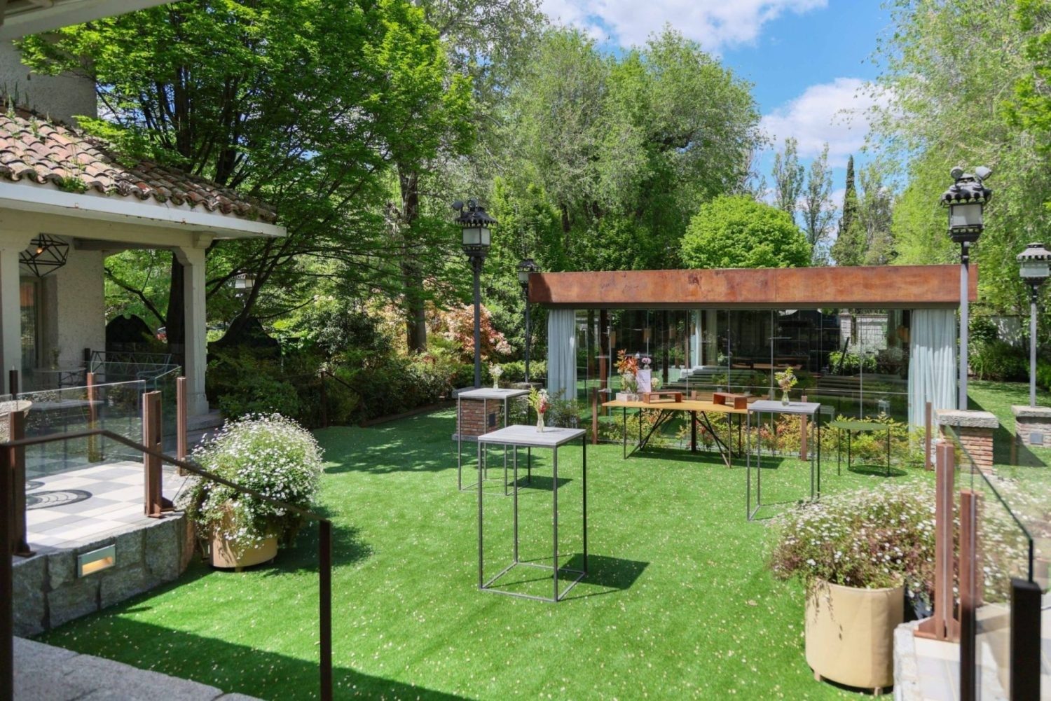 Jardín amplio con terraza y zona de estar al aire libre con mesas