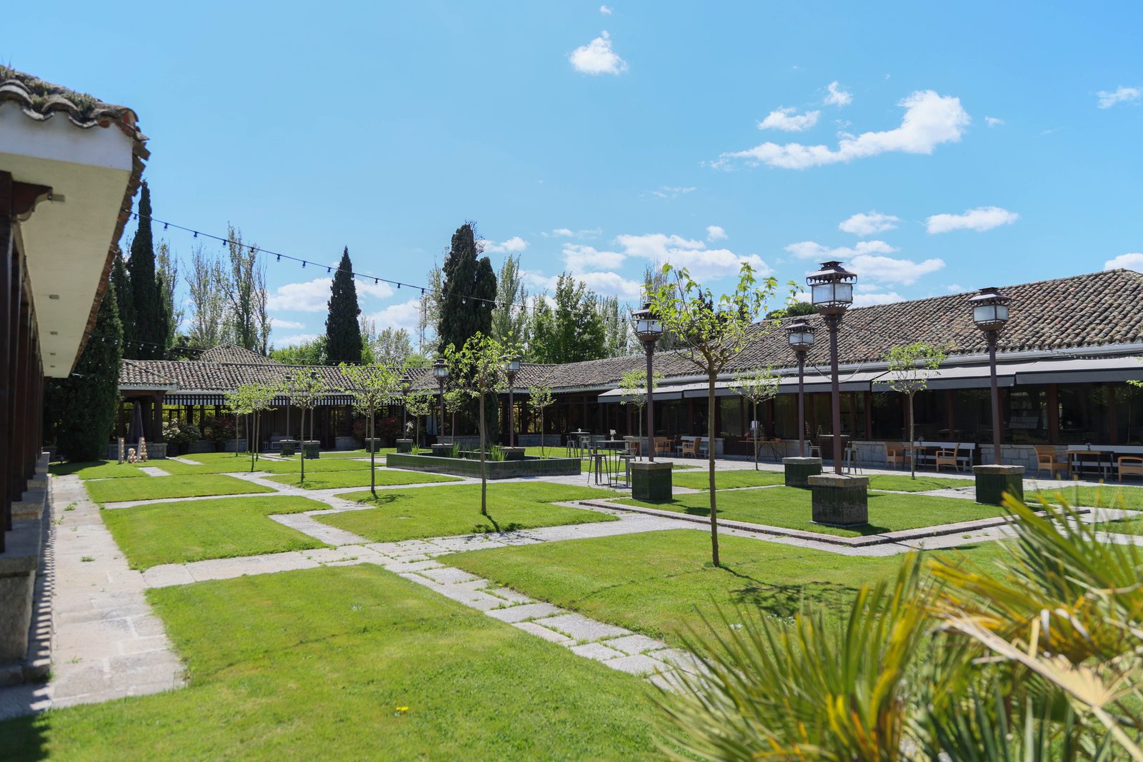 Patio ajardinado para bodas con césped y farolas