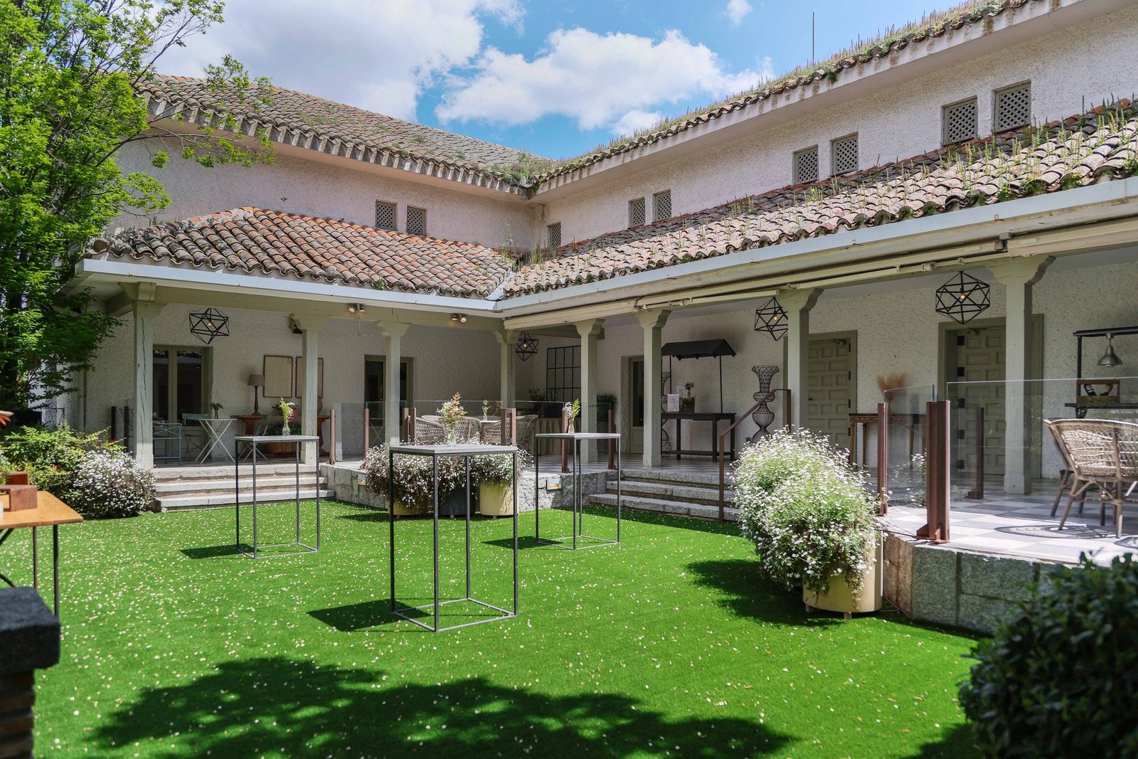 Porche y jardín con mesas altas de cóctel